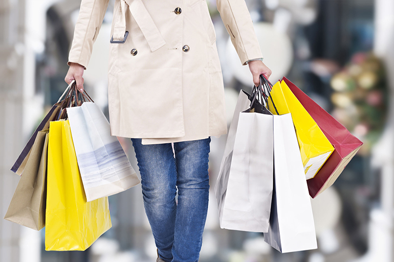 woman walking with shopping bags with christmas background.